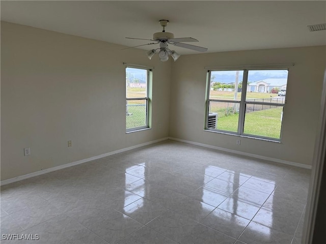 unfurnished room with ceiling fan and light tile patterned floors