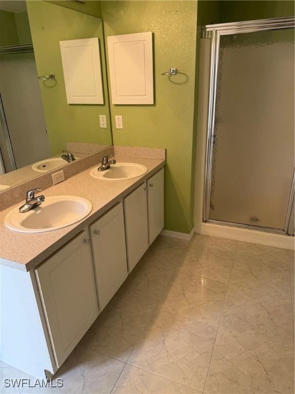 bathroom with a shower with shower door and vanity