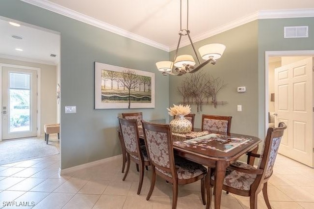 tiled dining space featuring an inviting chandelier and ornamental molding