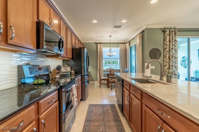 kitchen with sink, crown molding, light tile patterned flooring, light stone countertops, and appliances with stainless steel finishes