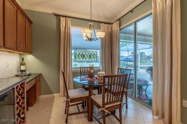 dining area with light tile patterned floors, a notable chandelier, and crown molding