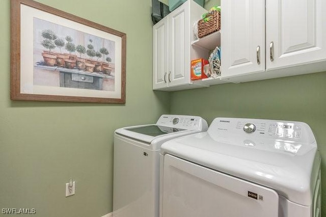 washroom with washing machine and dryer and cabinets