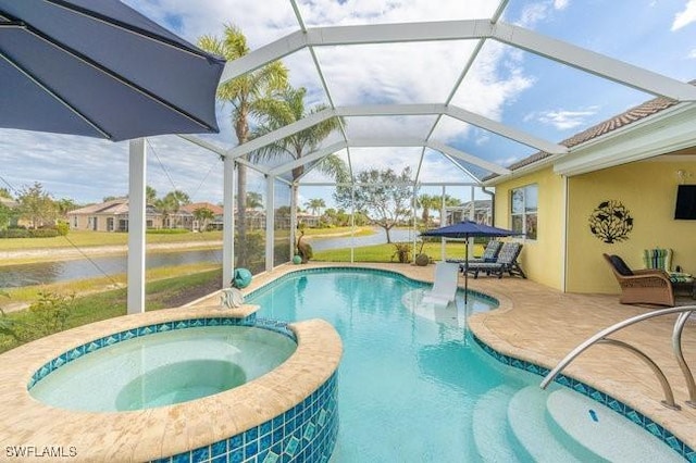 view of pool with glass enclosure, a patio area, and an in ground hot tub