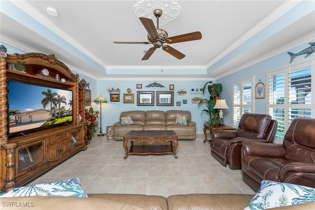 living area featuring light tile patterned floors, a tray ceiling, and ornamental molding