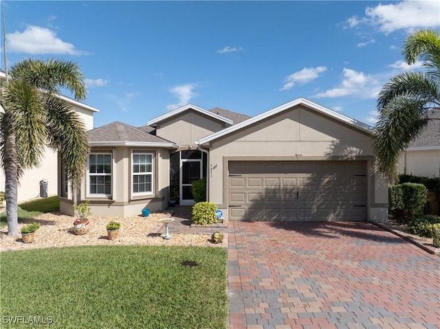 single story home featuring a garage and a front lawn