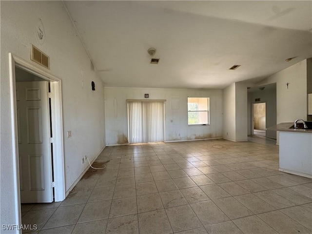 spare room with light tile patterned floors, visible vents, and a sink