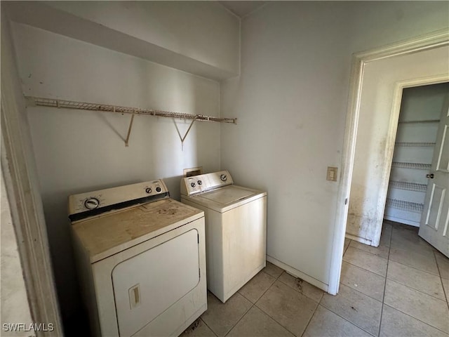 washroom featuring laundry area, independent washer and dryer, and light tile patterned floors