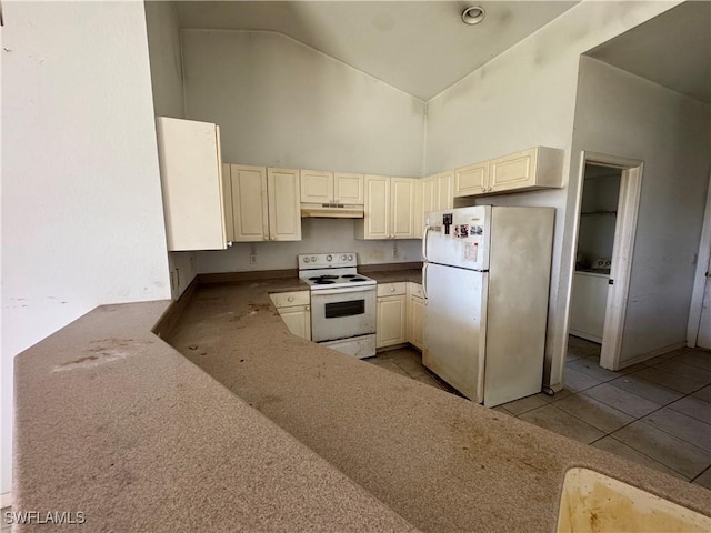 kitchen featuring white appliances, light tile patterned floors, cream cabinetry, under cabinet range hood, and high vaulted ceiling