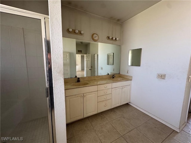 bathroom with a sink, a shower stall, and double vanity