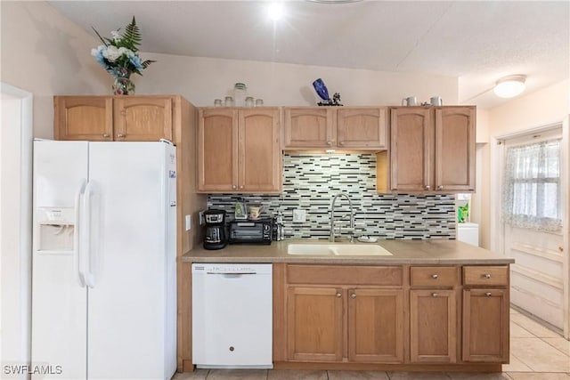 kitchen featuring sink, white appliances, tasteful backsplash, and light tile patterned flooring