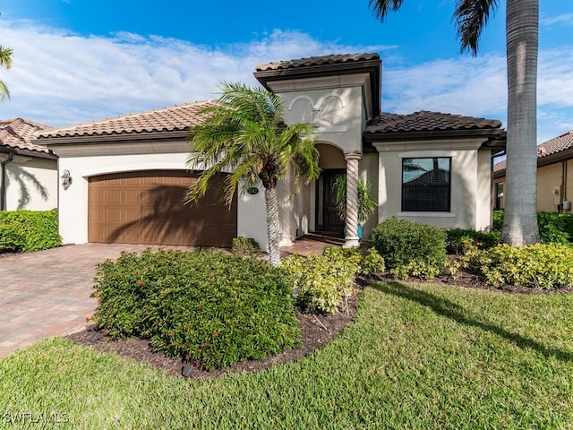 mediterranean / spanish-style house with a garage and a front yard