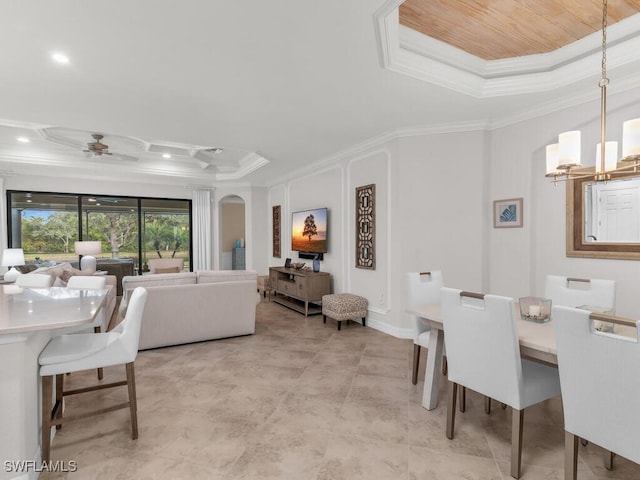 dining room featuring crown molding, a tray ceiling, and ceiling fan with notable chandelier