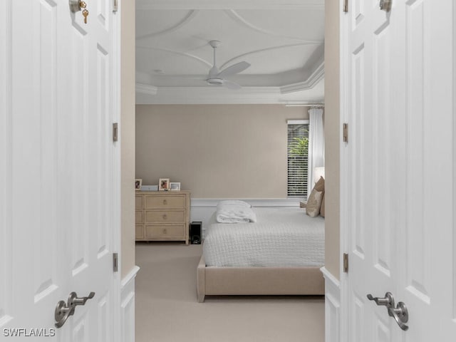 bedroom with a tray ceiling, ceiling fan, and carpet flooring