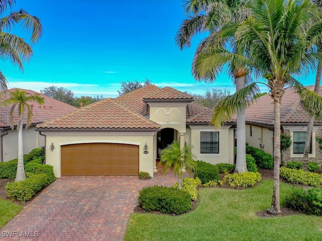 mediterranean / spanish-style house featuring a garage and a front yard