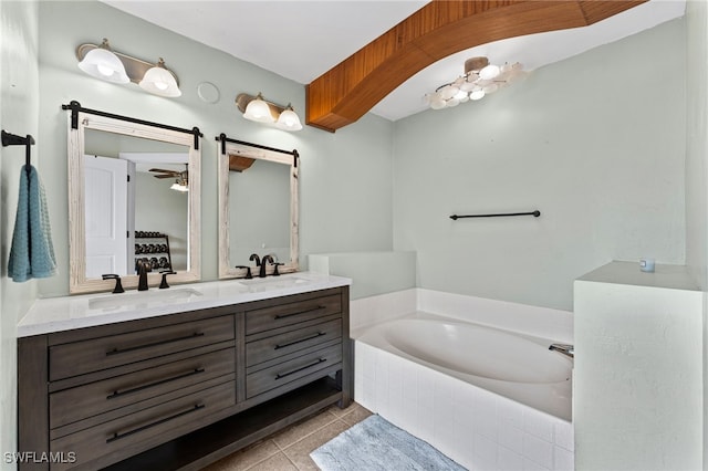 bathroom with tiled bath, tile patterned floors, and vanity