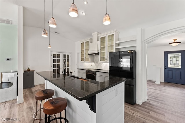 kitchen featuring a spacious island, lofted ceiling, decorative light fixtures, tasteful backsplash, and a breakfast bar