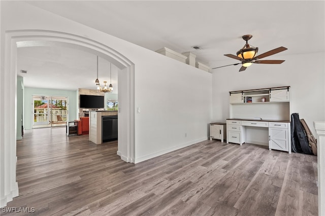 unfurnished office featuring hardwood / wood-style floors and ceiling fan with notable chandelier