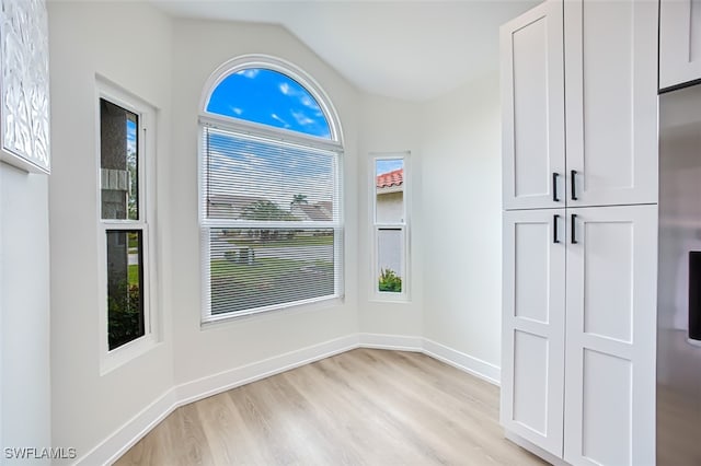 interior space with vaulted ceiling and light hardwood / wood-style flooring