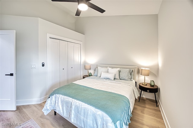 bedroom with ceiling fan, light hardwood / wood-style floors, and a closet