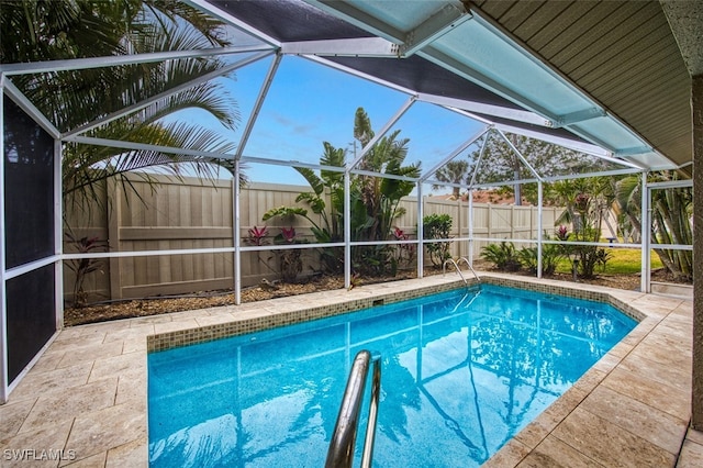 view of pool with a patio area and glass enclosure