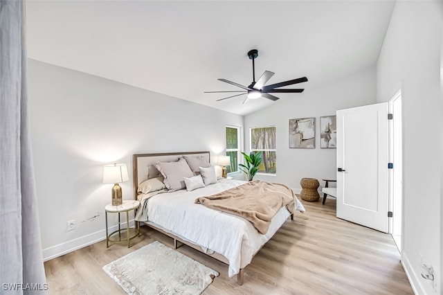 bedroom with ceiling fan, vaulted ceiling, and light hardwood / wood-style flooring