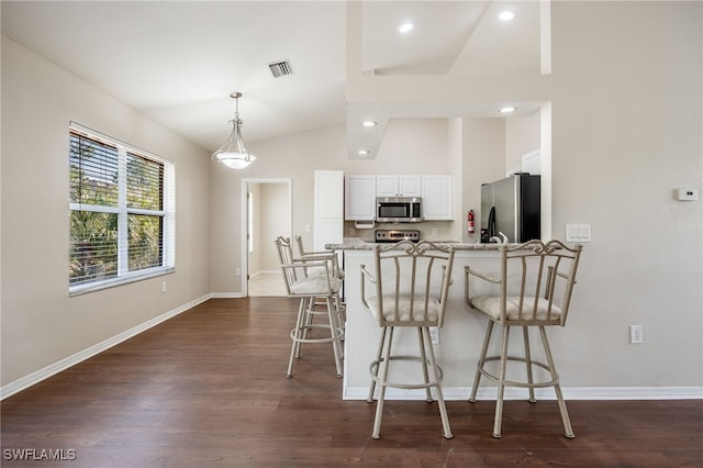 kitchen with visible vents, white cabinets, dark wood-style floors, decorative light fixtures, and stainless steel appliances