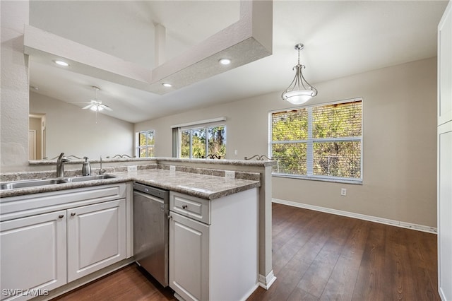 kitchen featuring stainless steel dishwasher, dark wood-type flooring, white cabinetry, a sink, and a peninsula