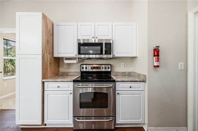 kitchen featuring appliances with stainless steel finishes, white cabinets, and light countertops