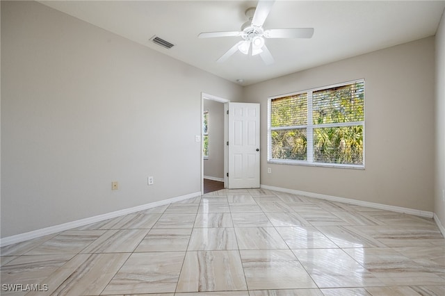 unfurnished room featuring a ceiling fan, visible vents, and baseboards