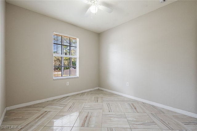 empty room featuring ceiling fan and baseboards