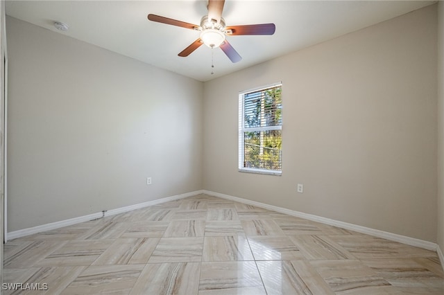 unfurnished room with ceiling fan and baseboards