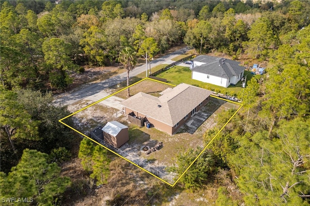 birds eye view of property with a forest view