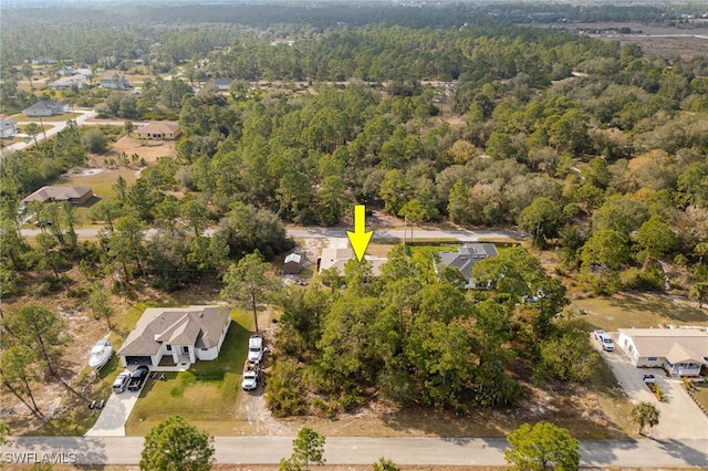 drone / aerial view featuring a forest view and a residential view