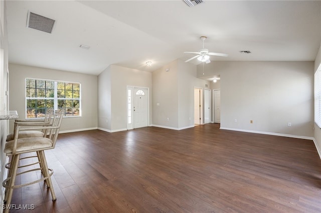 unfurnished living room featuring lofted ceiling, dark wood finished floors, visible vents, and baseboards