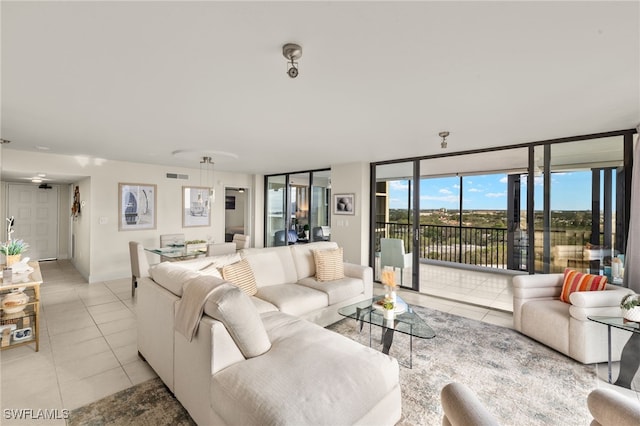 living area featuring light tile patterned floors, visible vents, and expansive windows