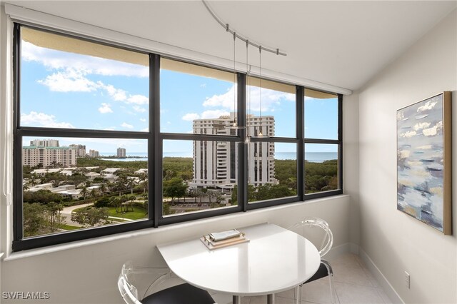 tiled dining space featuring a view of city and baseboards