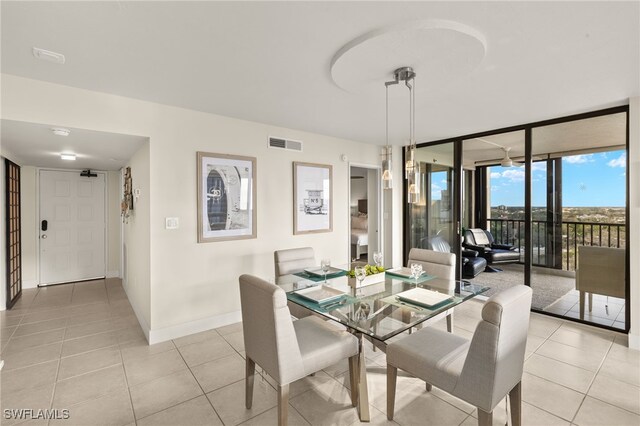 dining area with a wall of windows and light tile patterned floors