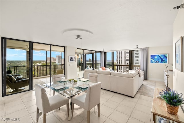dining room with light tile patterned floors, a healthy amount of sunlight, and expansive windows