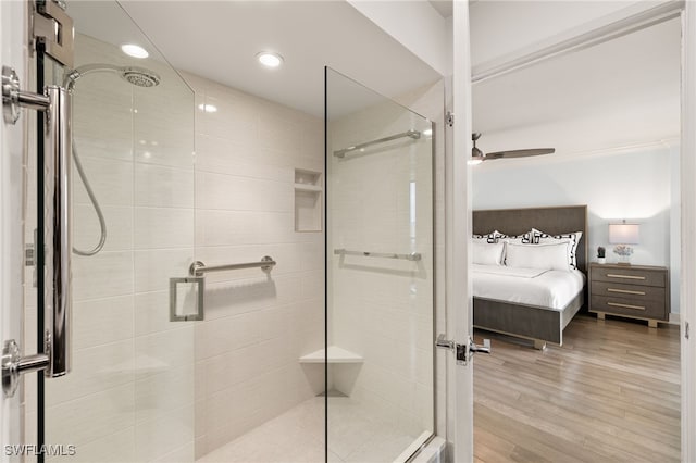 full bath featuring wood finished floors, ensuite bathroom, a ceiling fan, and a stall shower