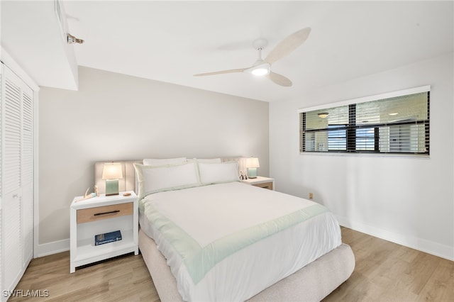bedroom with light wood finished floors, a closet, ceiling fan, and baseboards