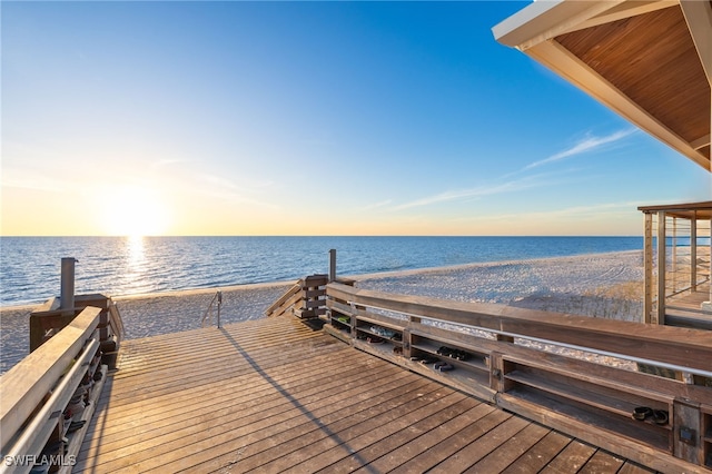 view of dock with a beach view and a water view