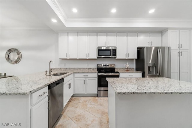 kitchen featuring light stone countertops, white cabinets, stainless steel appliances, sink, and ornamental molding