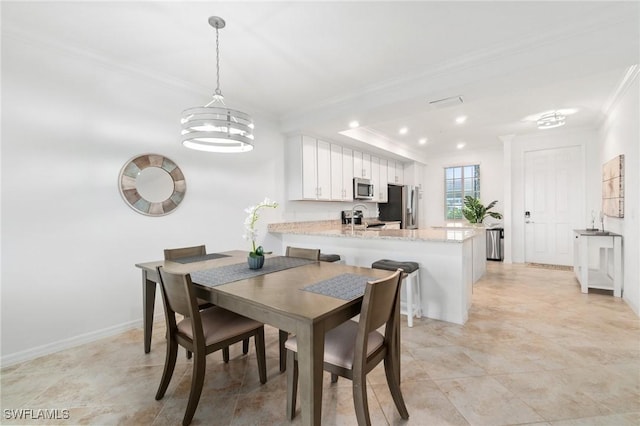 dining space featuring sink and ornamental molding