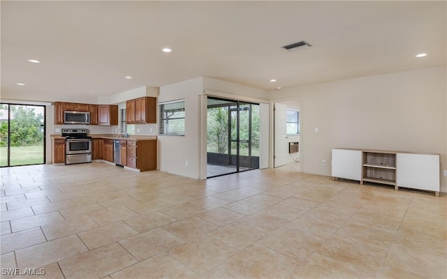 kitchen with stainless steel appliances, light tile patterned flooring, and plenty of natural light