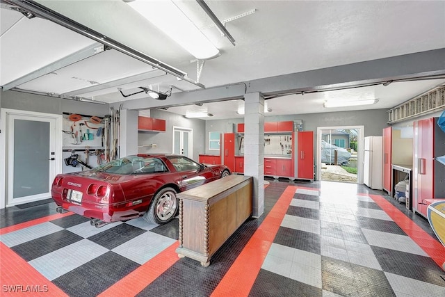 garage with a garage door opener and white fridge