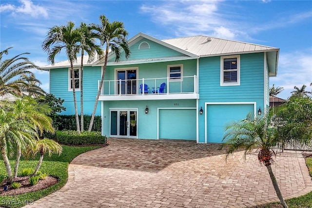 view of front of property featuring a garage, french doors, and a balcony