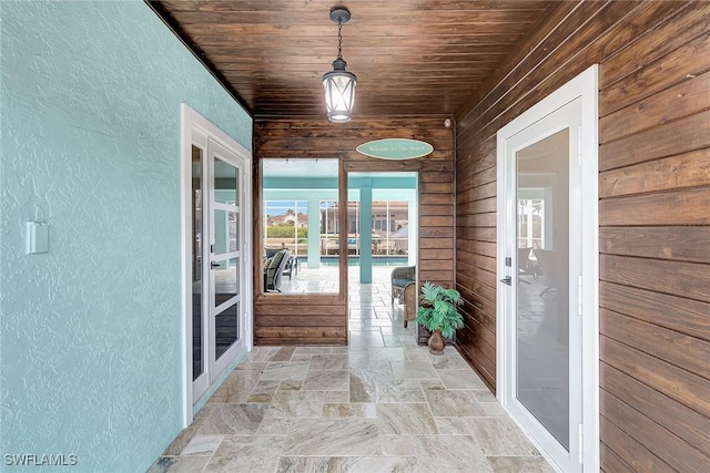 unfurnished sunroom featuring wood ceiling and french doors