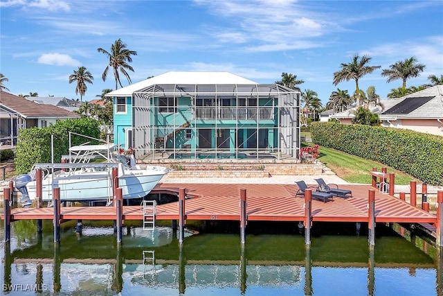 rear view of house with a water view and a lanai