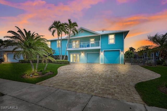 view of front of property with french doors, a balcony, and a yard