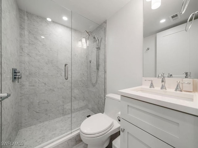 bathroom with vanity, toilet, and a shower with shower door